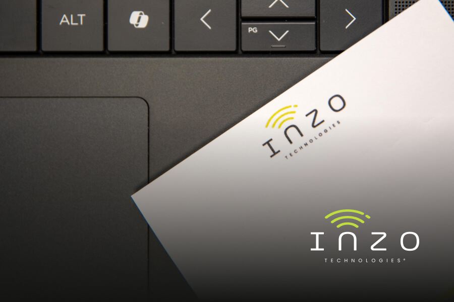An Inzo Technologies-branded notepad sits on a laptop keyboard