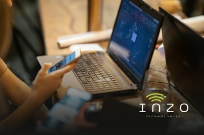 A woman uses her cellphone with her laptop open