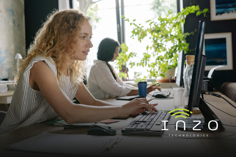 Two women work at computers next to each other