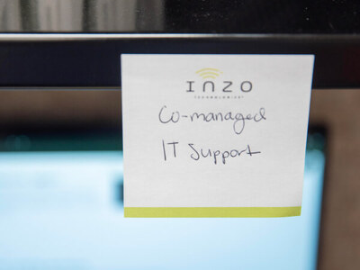 Inzo Technologies notepad with “Co-managed IT Support” handwritten on it, attached to a computer monitor