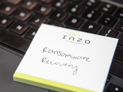 Inzo Technologies notepad with “Ransomware Recovery” handwritten on it, resting on a laptop keyboard