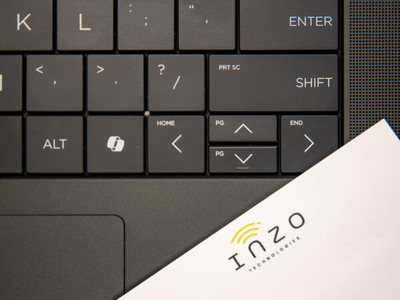 Close up of a laptop keyboard with an Inzo Technologies branded sticky note pad.