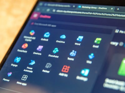 Microsoft 365 app launcher displayed on a computer screen with icons for Outlook, OneDrive, Word, Excel, OneNote, SharePoint, Teams, Power Automate, and other Microsoft apps