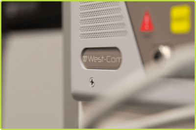 Close-up of a West-Com NOVUS Connect patient station with speaker grille and color-coded call controls