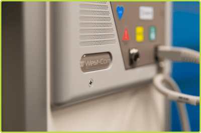 West-Com NOVUS Connect patient station with speaker, color-coded call buttons, and connected patient cables